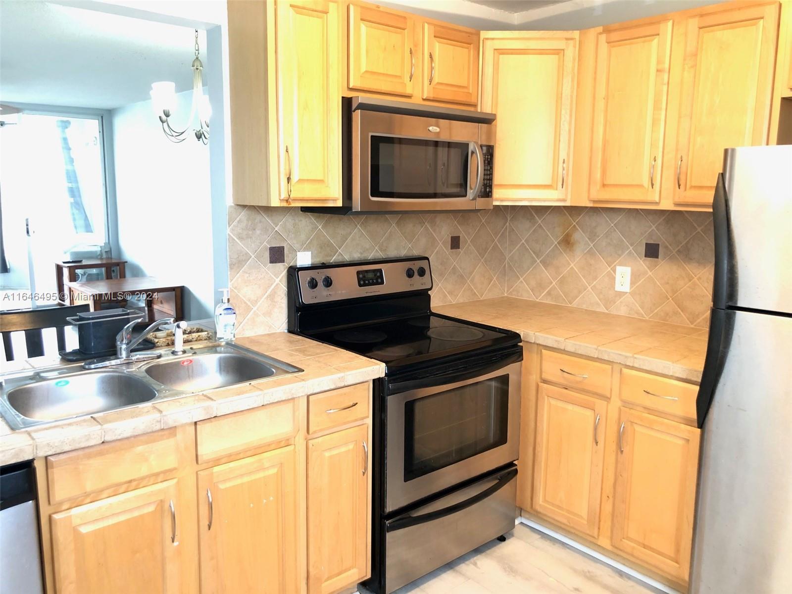 a kitchen with stainless steel appliances granite countertop a sink stove and microwave