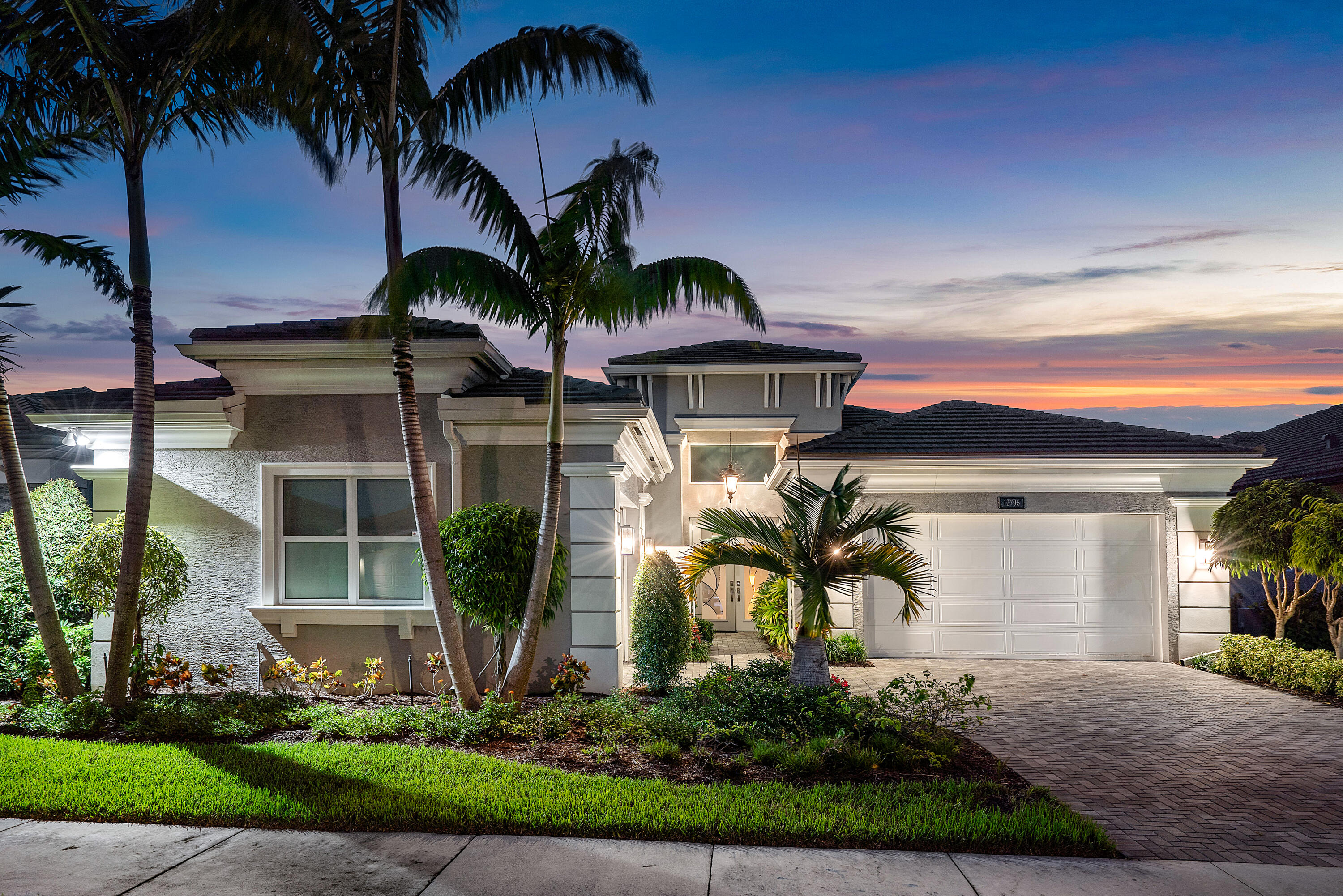 front view of house with a yard and palm trees