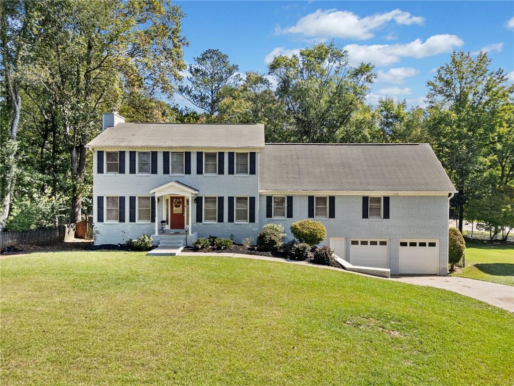 a front view of a house with yard and green space