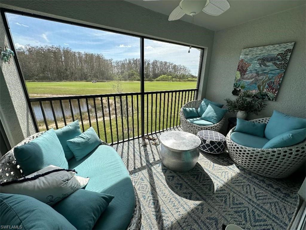 a living room with furniture and a floor to ceiling window