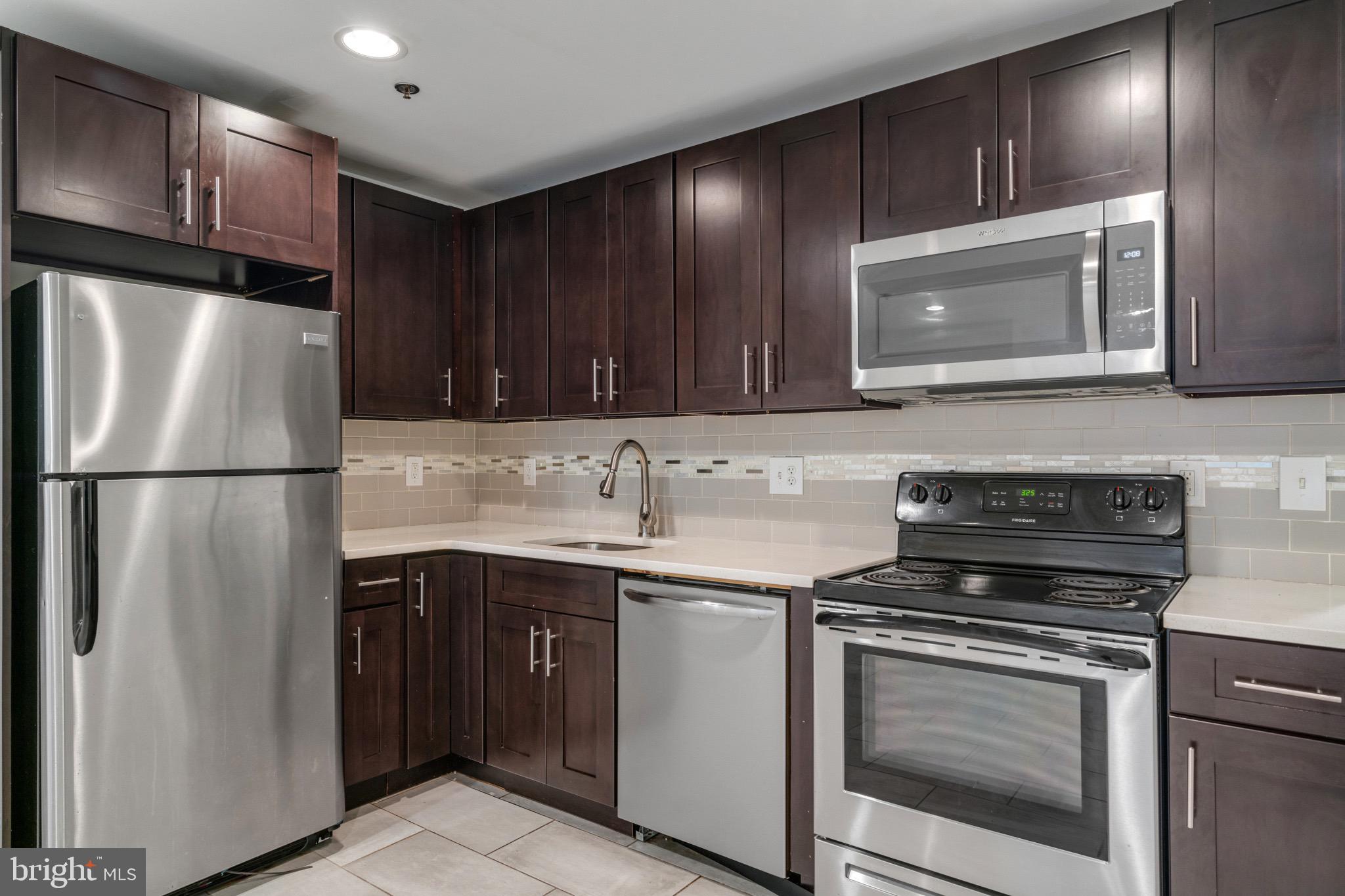 a kitchen with a sink stove and refrigerator