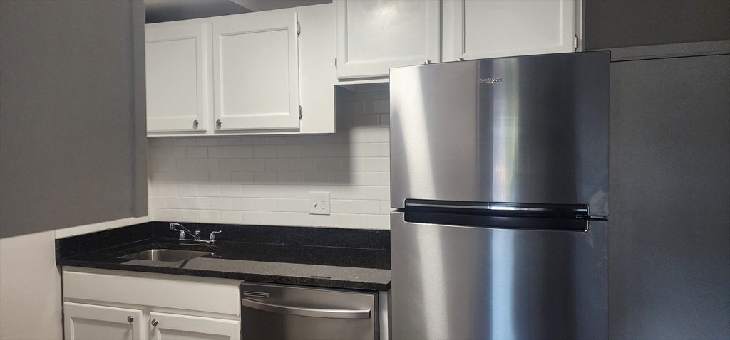 a kitchen with a refrigerator and cabinets