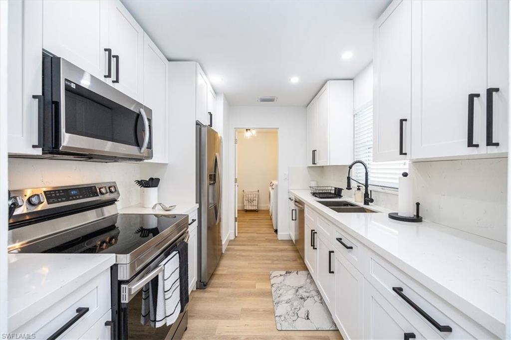 a kitchen with a sink stove and microwave