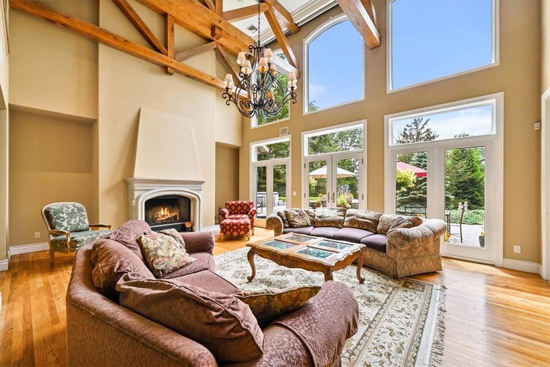 Living room featuring high vaulted ceiling, a fireplace, wood-type flooring, and plenty of natural light