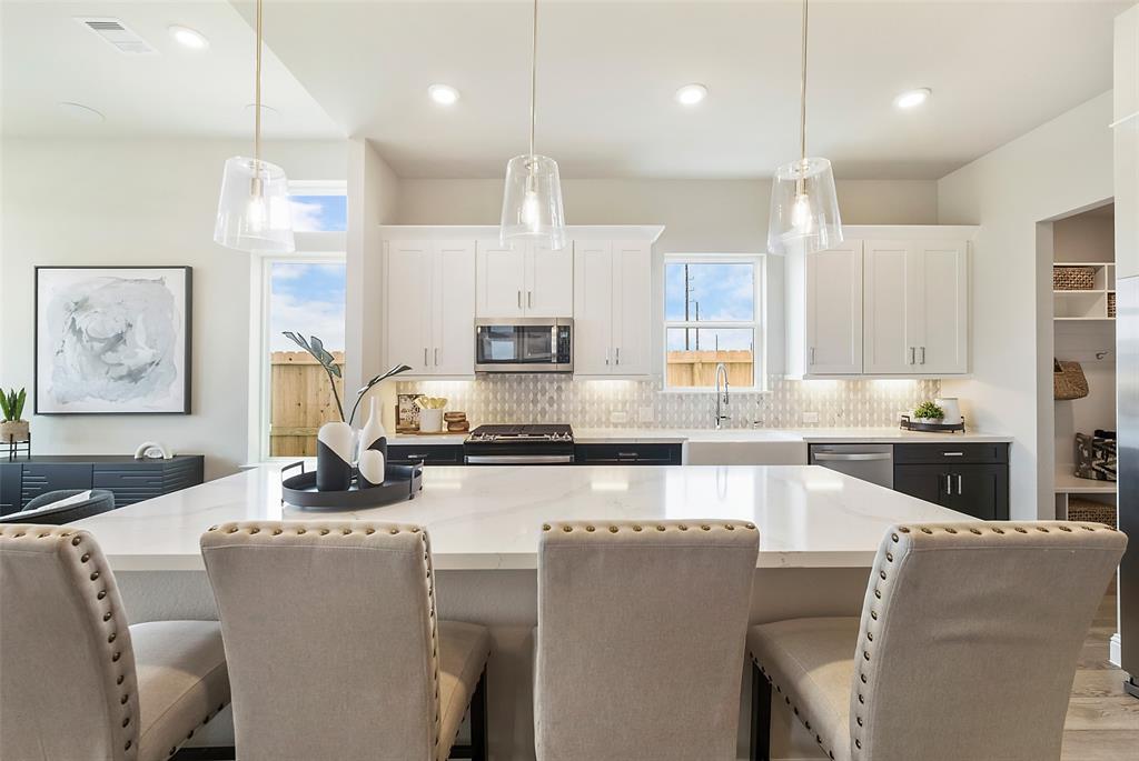 a large kitchen with kitchen island a large counter top space appliances and cabinets