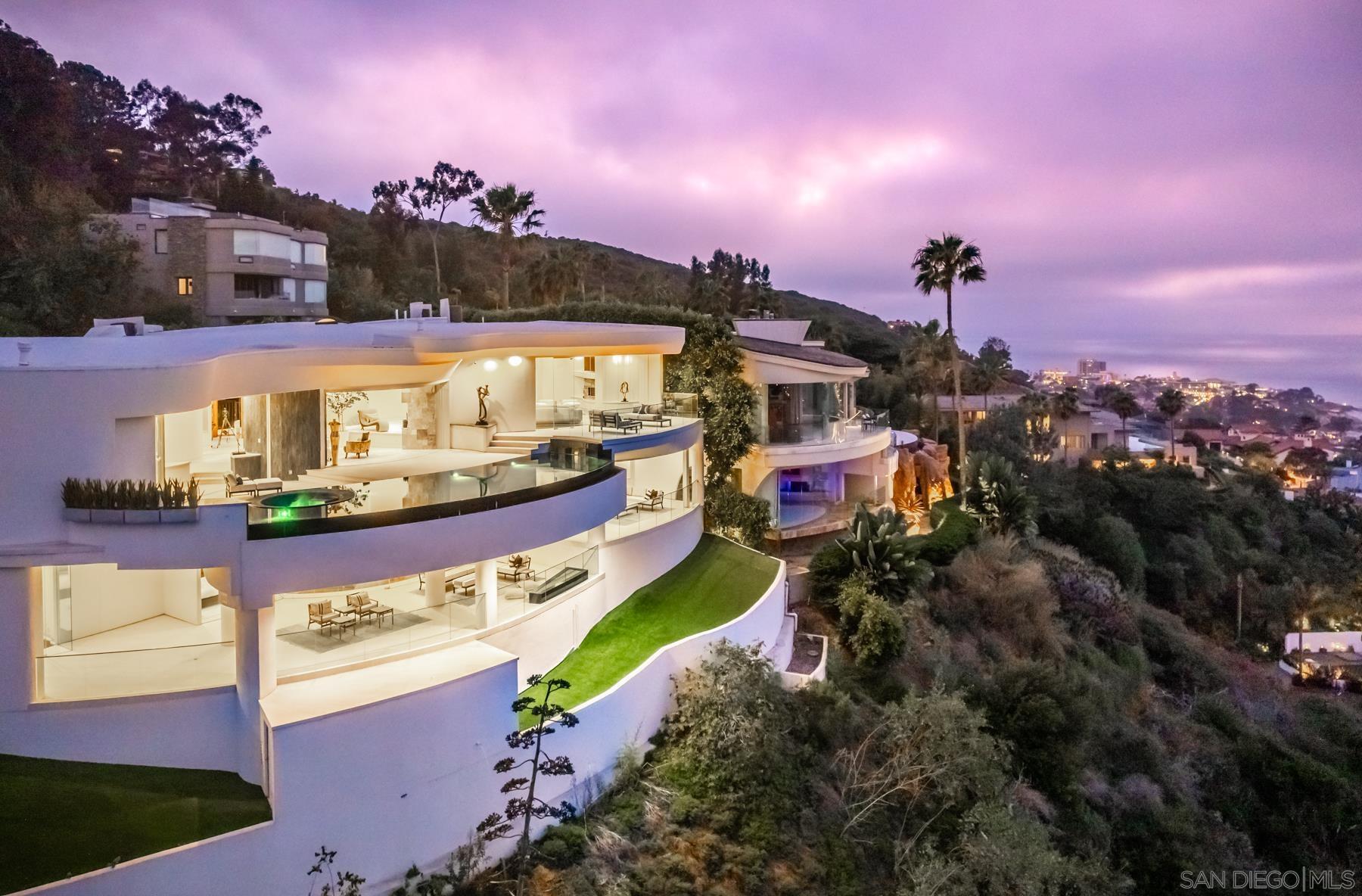 a view of a house with a yard and a lot of trees