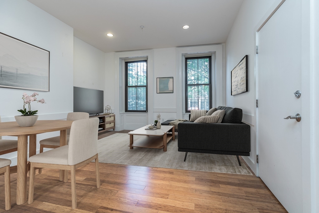 a living room with furniture a wooden floor and a large window