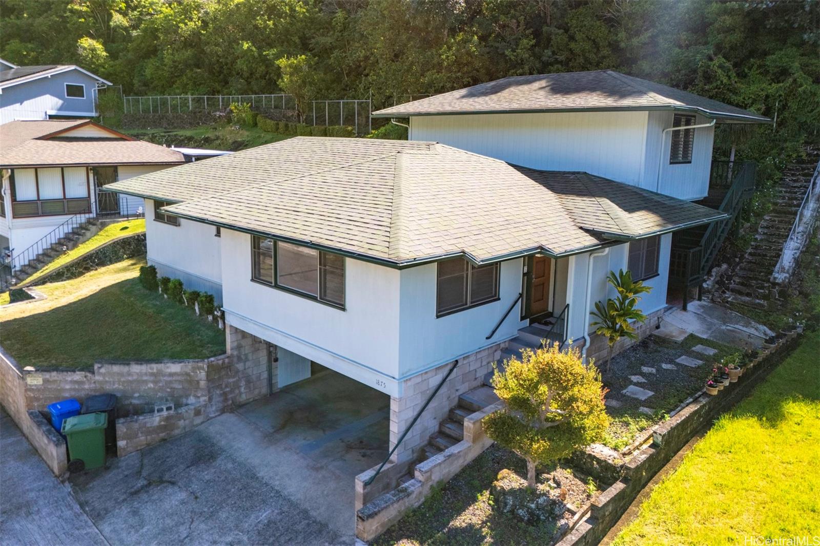 an aerial view of a house with swimming pool and large trees