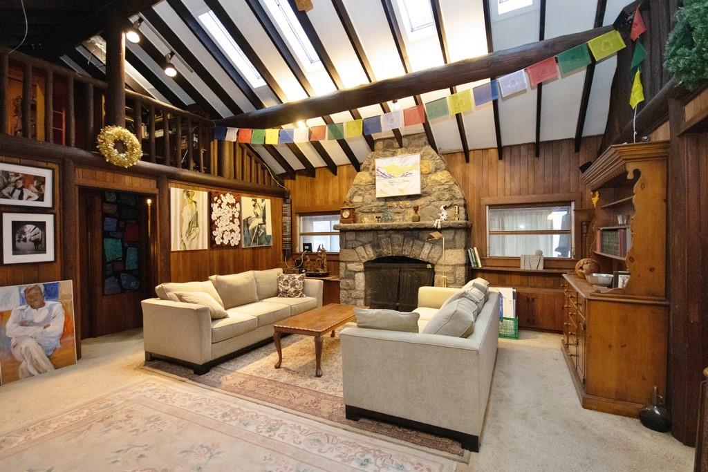 Living room featuring high vaulted ceiling and paneled walls