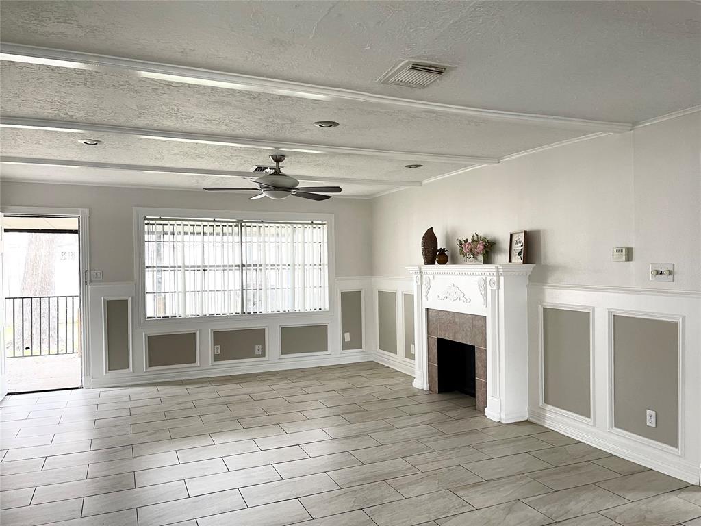 a view of a livingroom with a fireplace cabinet and windows