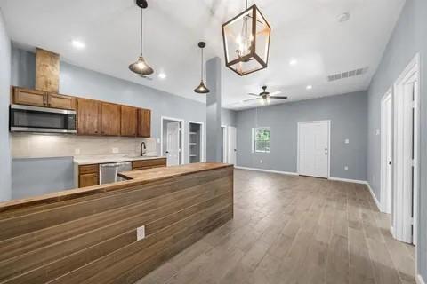 a view of a kitchen with a sink and dishwasher a refrigerator with wooden floor