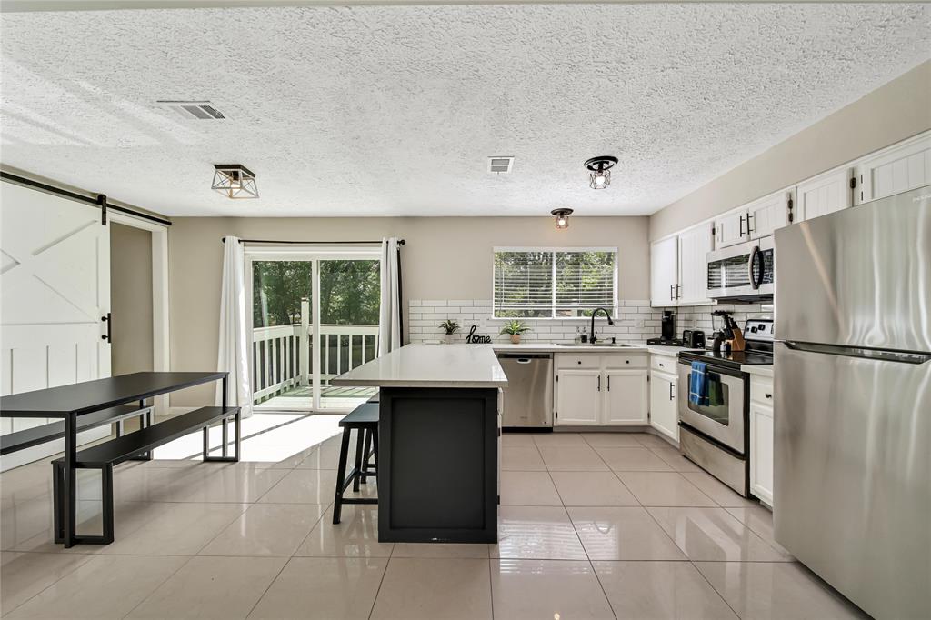 a kitchen with a refrigerator a sink and chairs