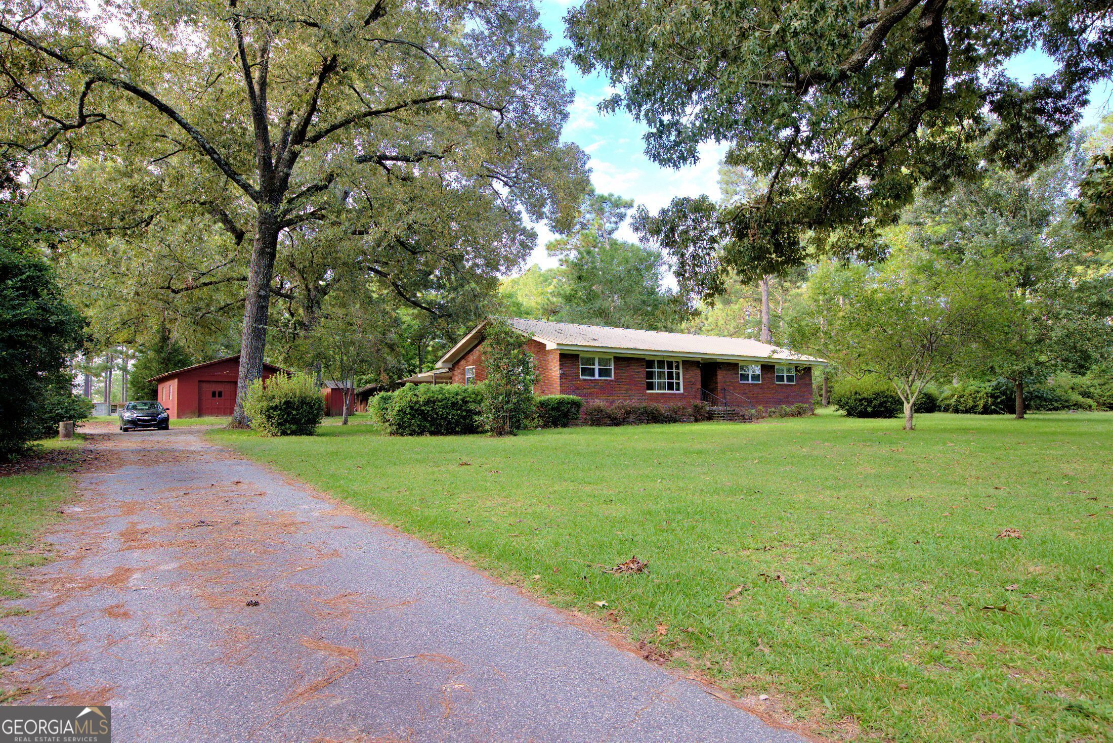 a front view of a house with a yard and trees