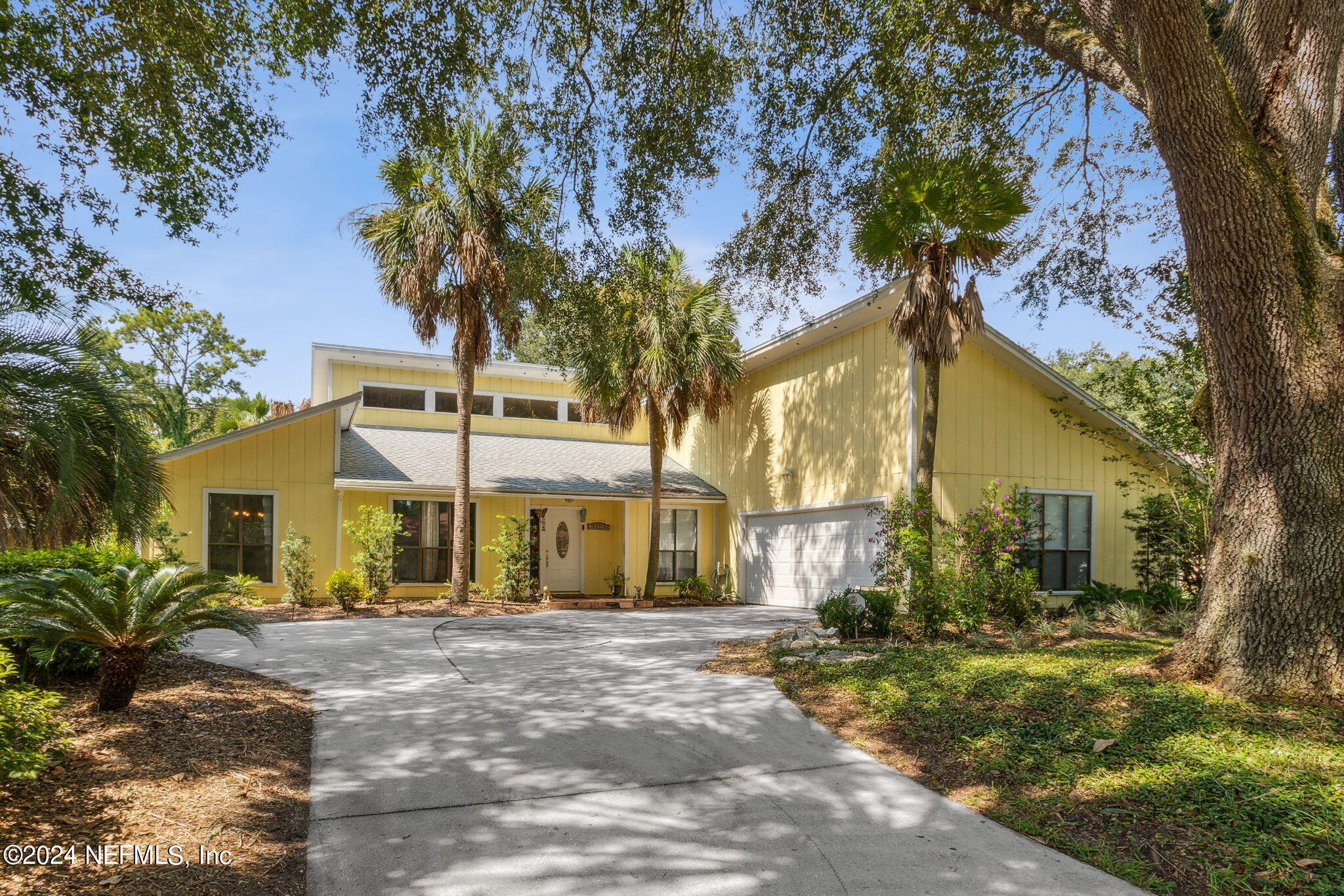 a front view of a house with a yard and tree s