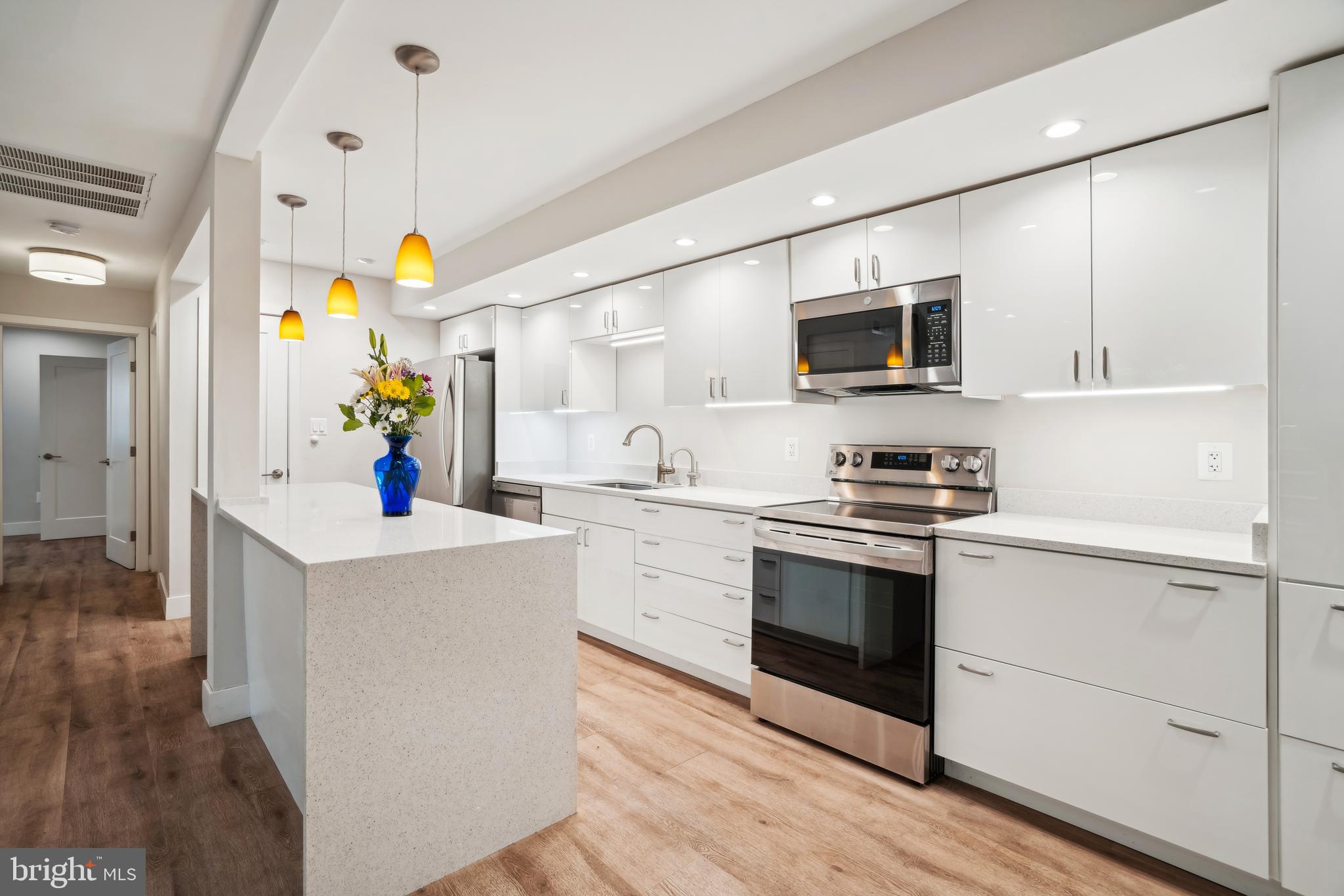 a kitchen with a sink cabinets and wooden floor