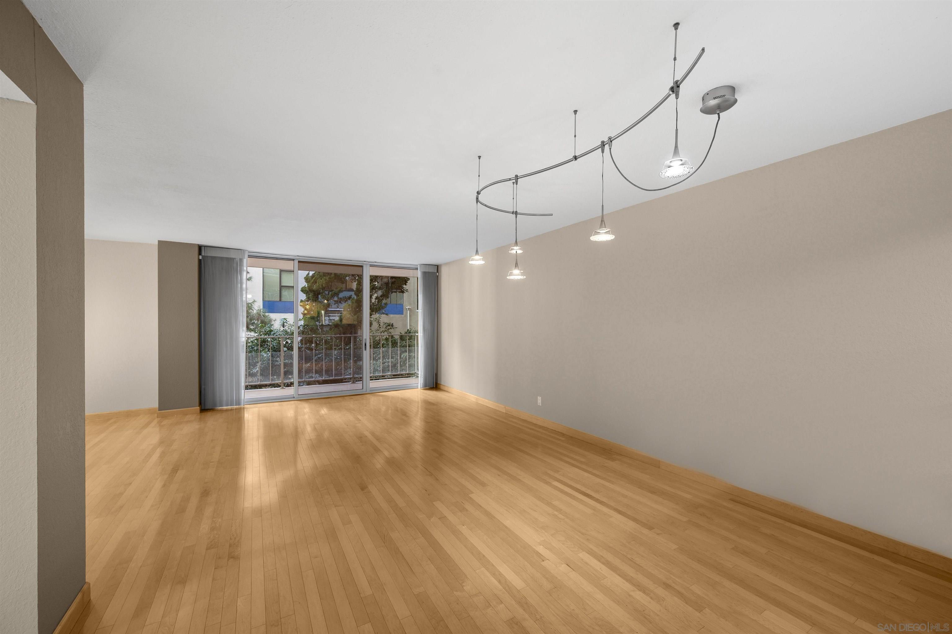 a view of empty room with wooden floor and windows