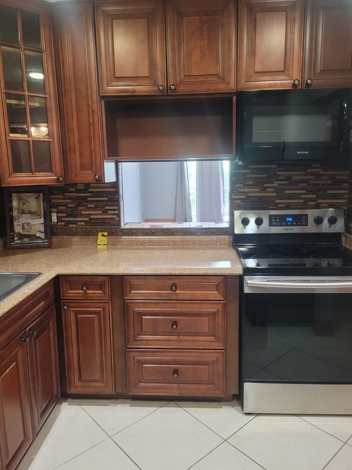 a kitchen with granite countertop wooden cabinets and a stove top oven