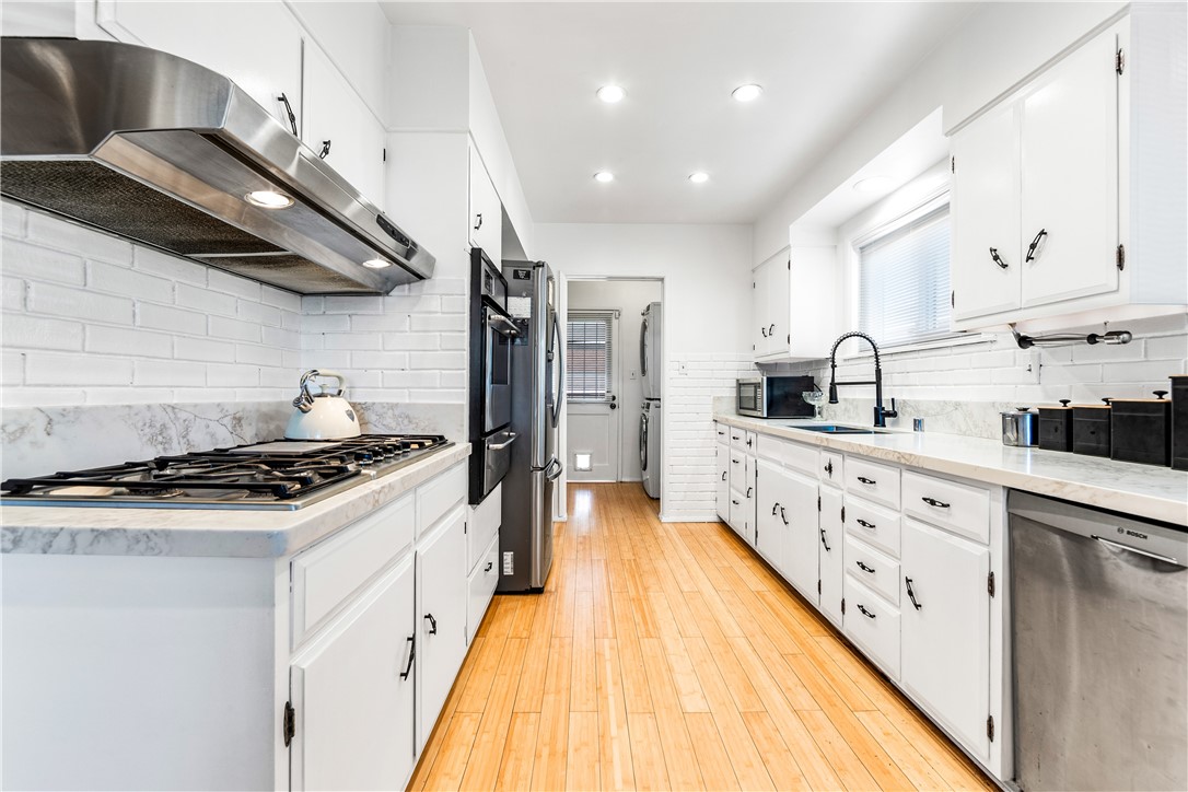 a spacious kitchen with stainless steel appliances granite countertop a lot of counter space and wooden floors