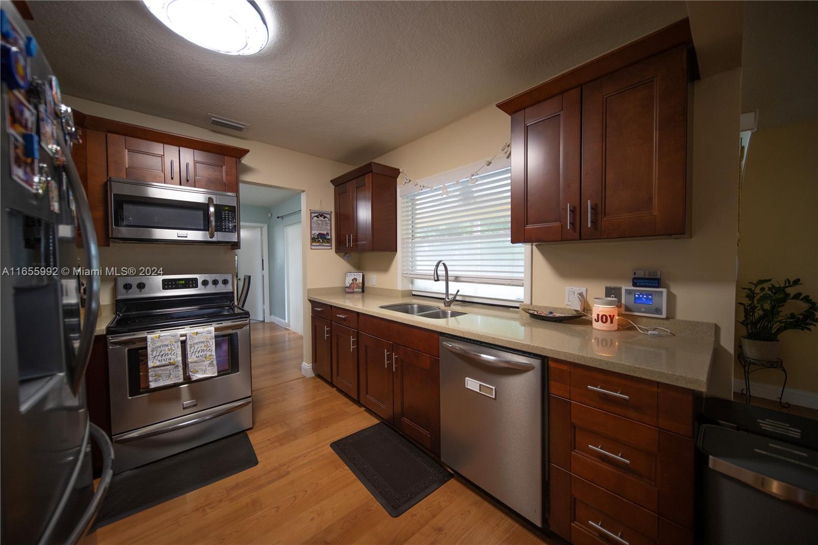 a kitchen with kitchen island granite countertop stainless steel appliances and wooden cabinets