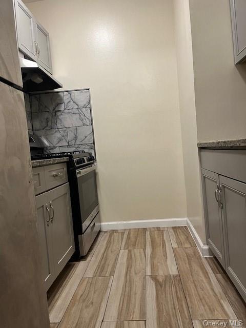 a view of a kitchen with wooden floor and a stove top oven