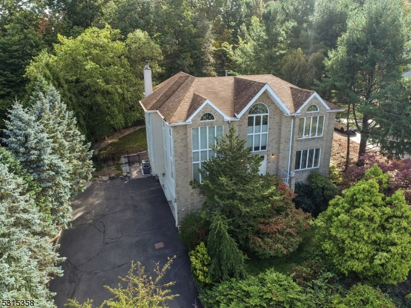 a front view of a house with a yard and large trees