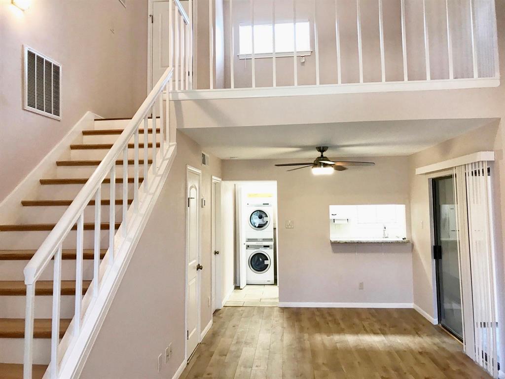 a view of a hallway with wooden floor and staircase