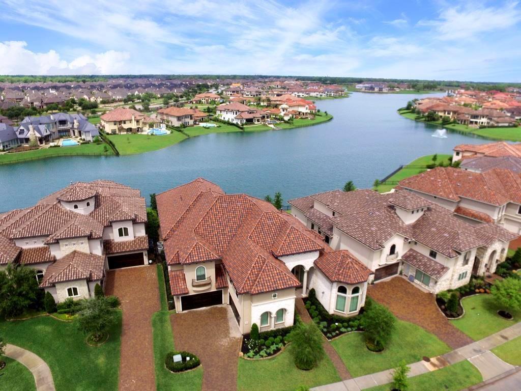 an aerial view of residential houses with outdoor space and ocean view