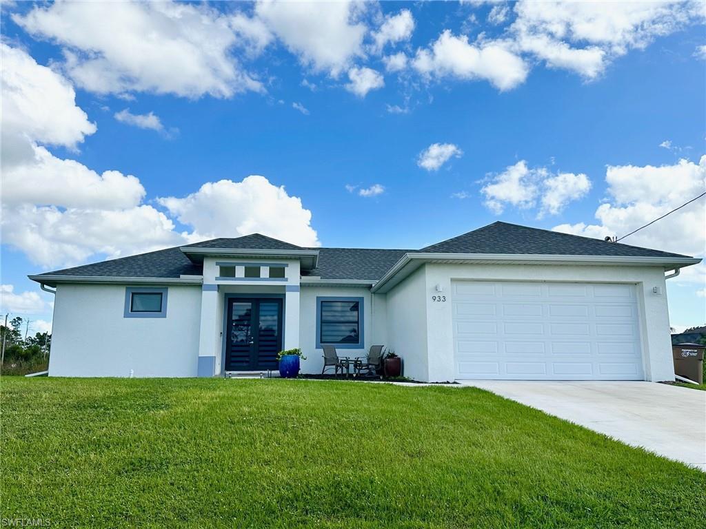 View of front of house with french doors, a front lawn, and a garage