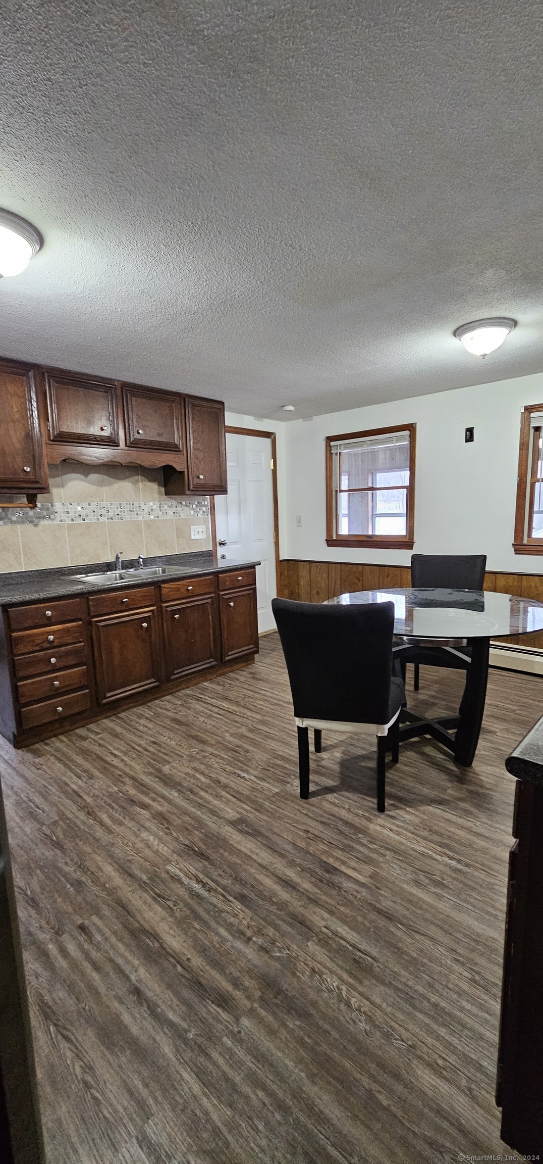 a living room with furniture a rug and kitchen view