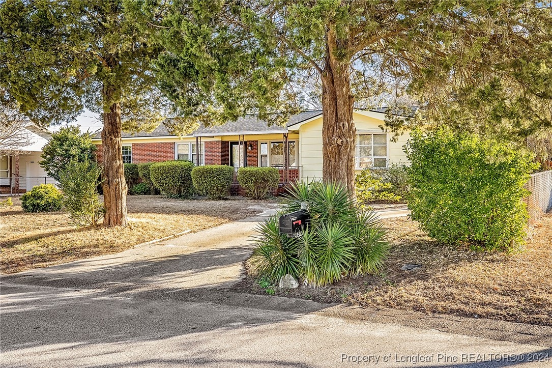 a front view of a house with a yard and trees