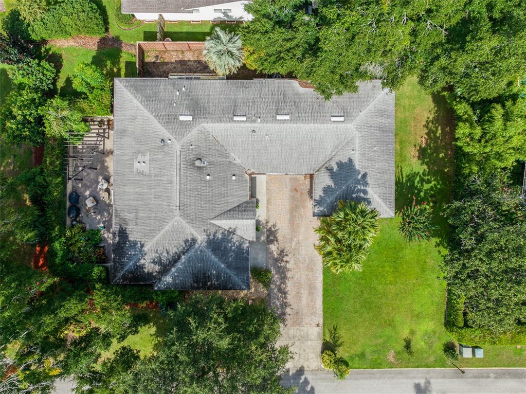 an aerial view of a house with a yard and large tree