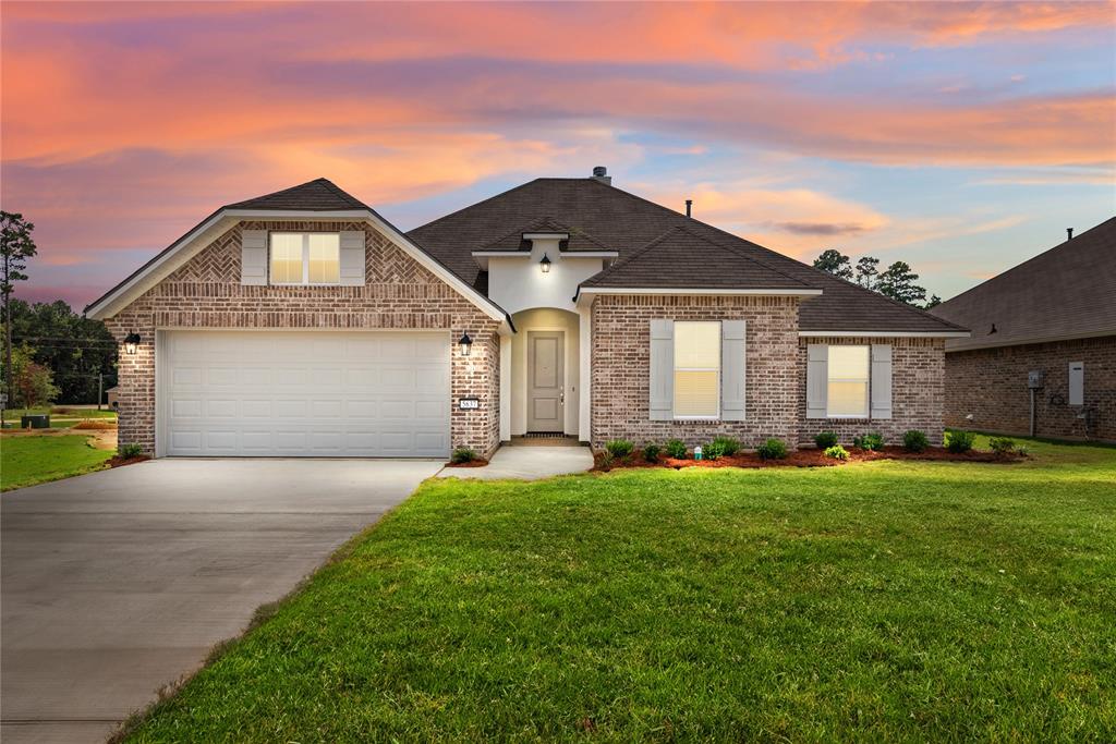 a front view of a house with a yard and garage