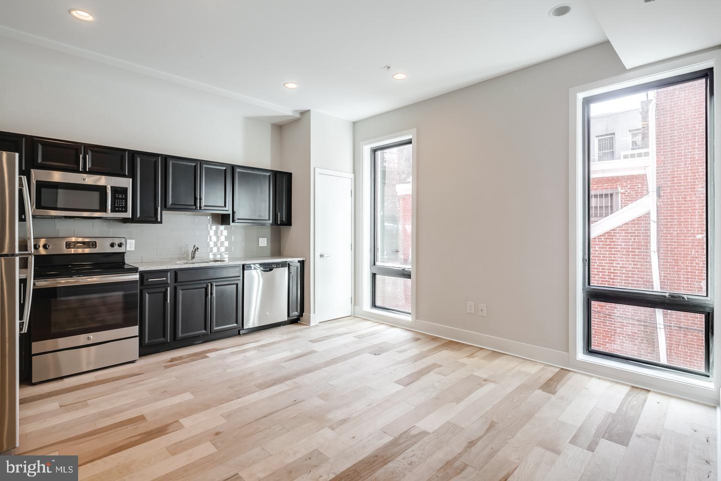 a kitchen with stainless steel appliances a refrigerator and a stove top oven