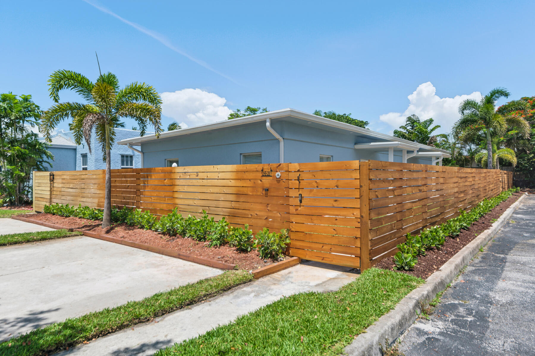 a front view of a house with a yard and potted plants