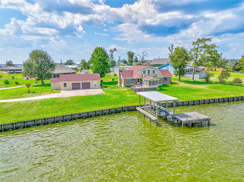 a aerial view of a house with swimming pool garden and lake view