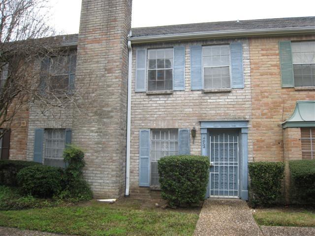 a view of a stone house with a small yard and plants