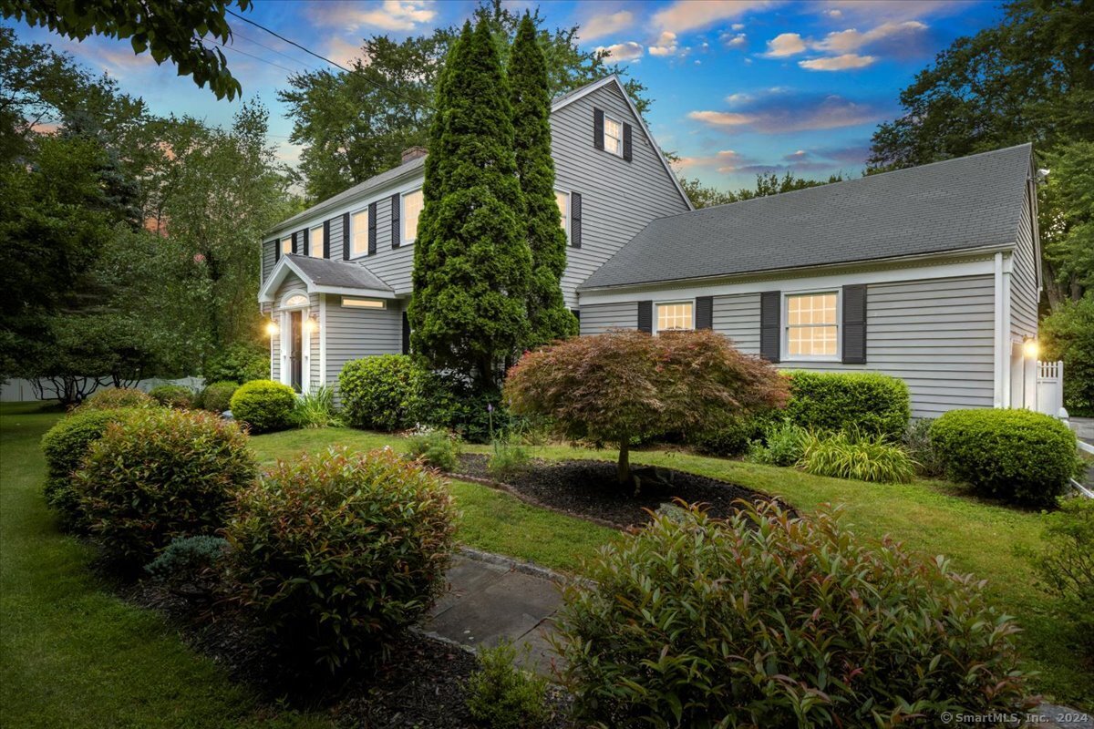 a view of a house with a yard and flower plants