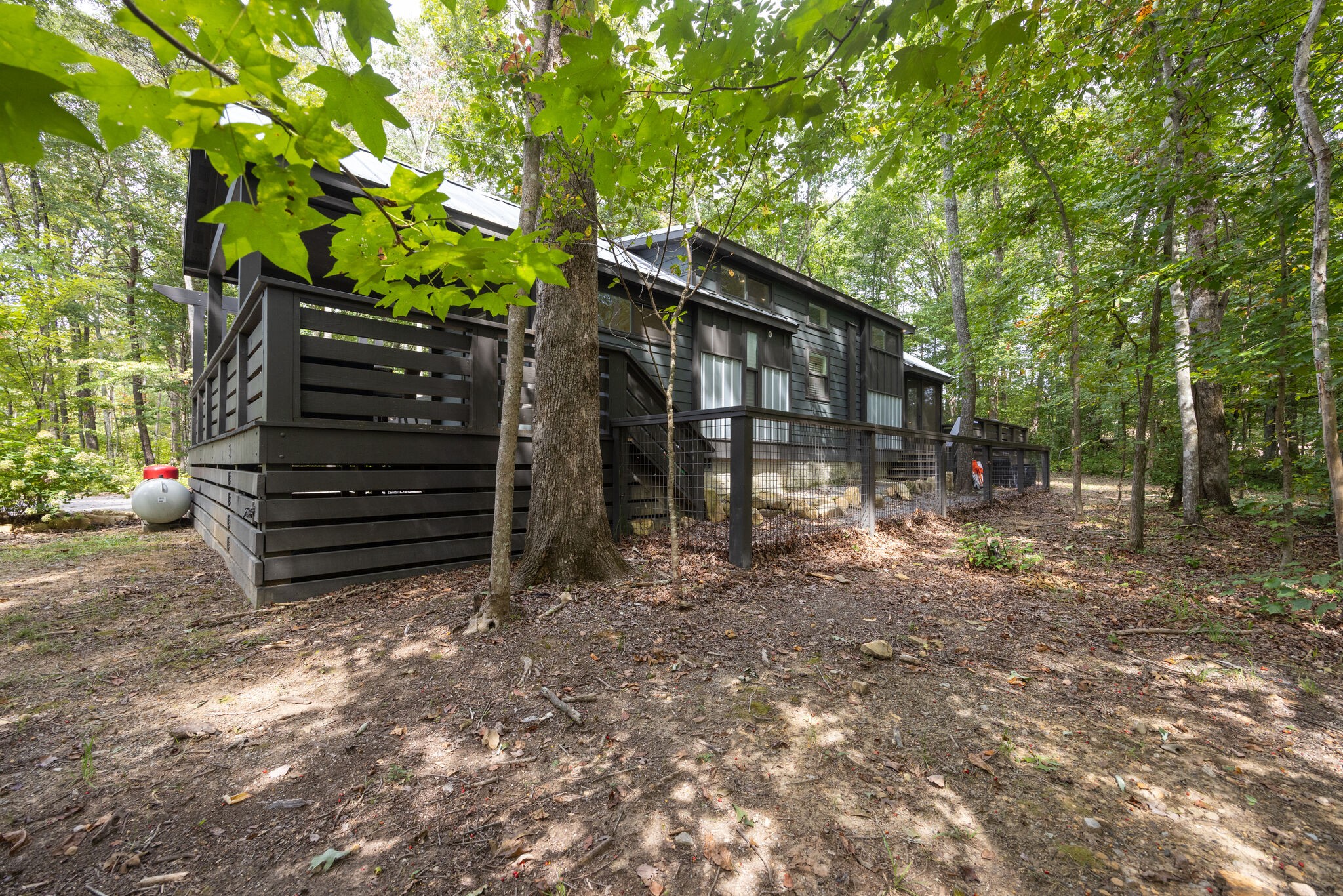 a backyard of a house with barbeque oven and trees