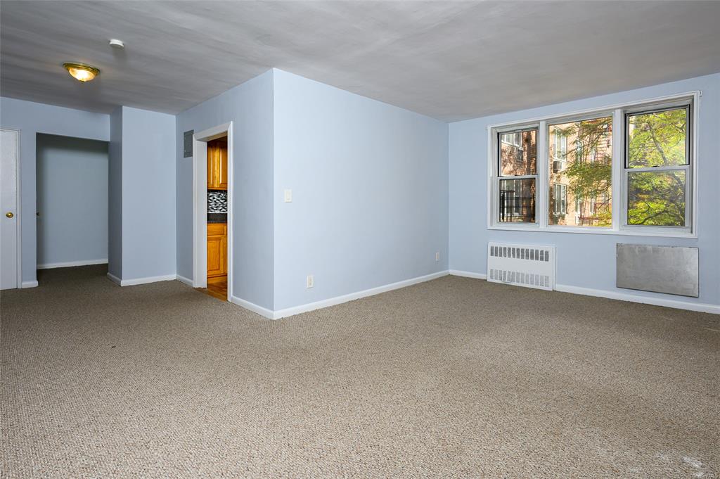 Empty room featuring carpet flooring and radiator