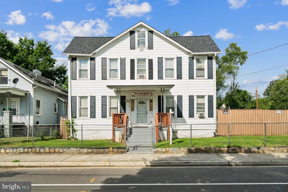 a front view of a house with a yard and potted plants