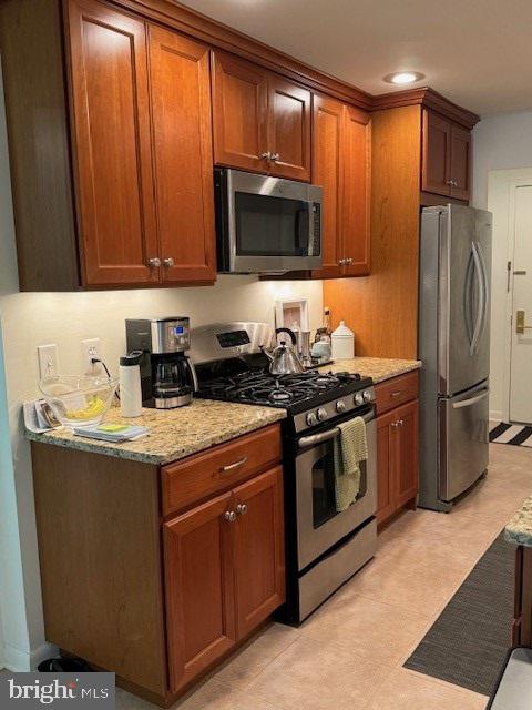 a kitchen with stainless steel appliances granite countertop a stove a refrigerator and a microwave