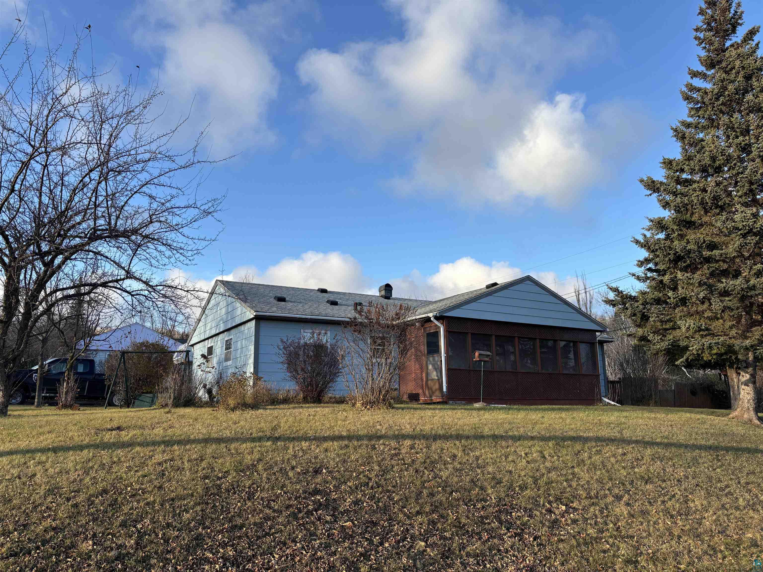 Back of house featuring a sunroom and a yard