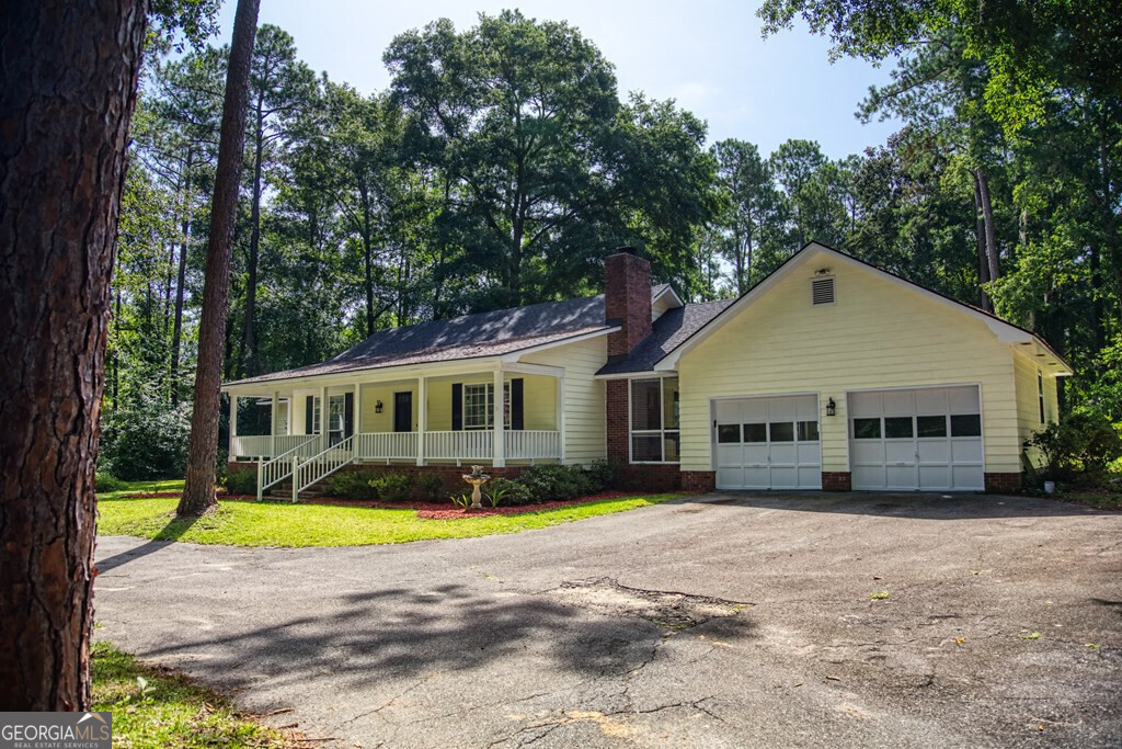 a view of a house next to a big yard with large trees