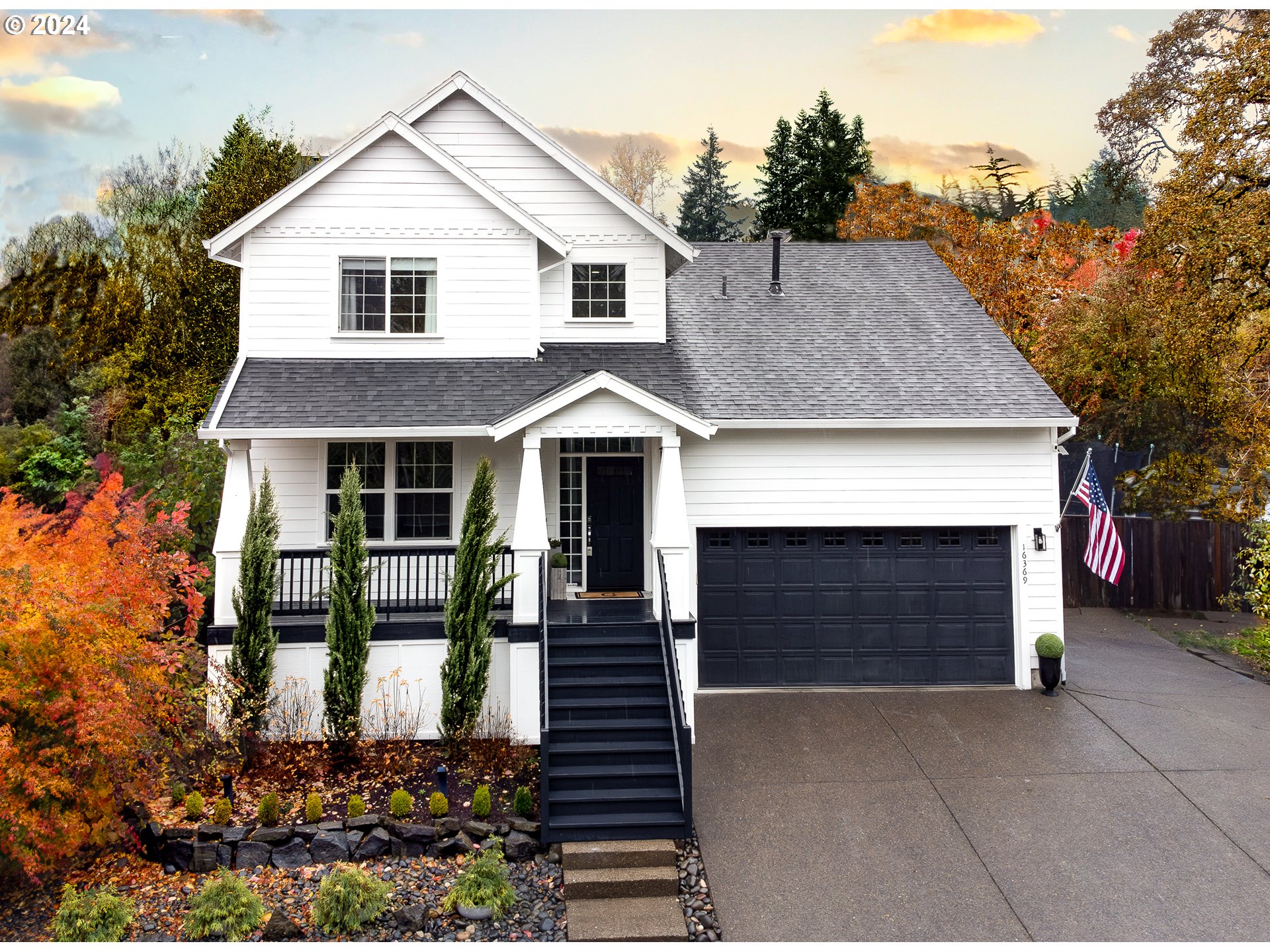 a front view of a house with a garage and outdoor seating