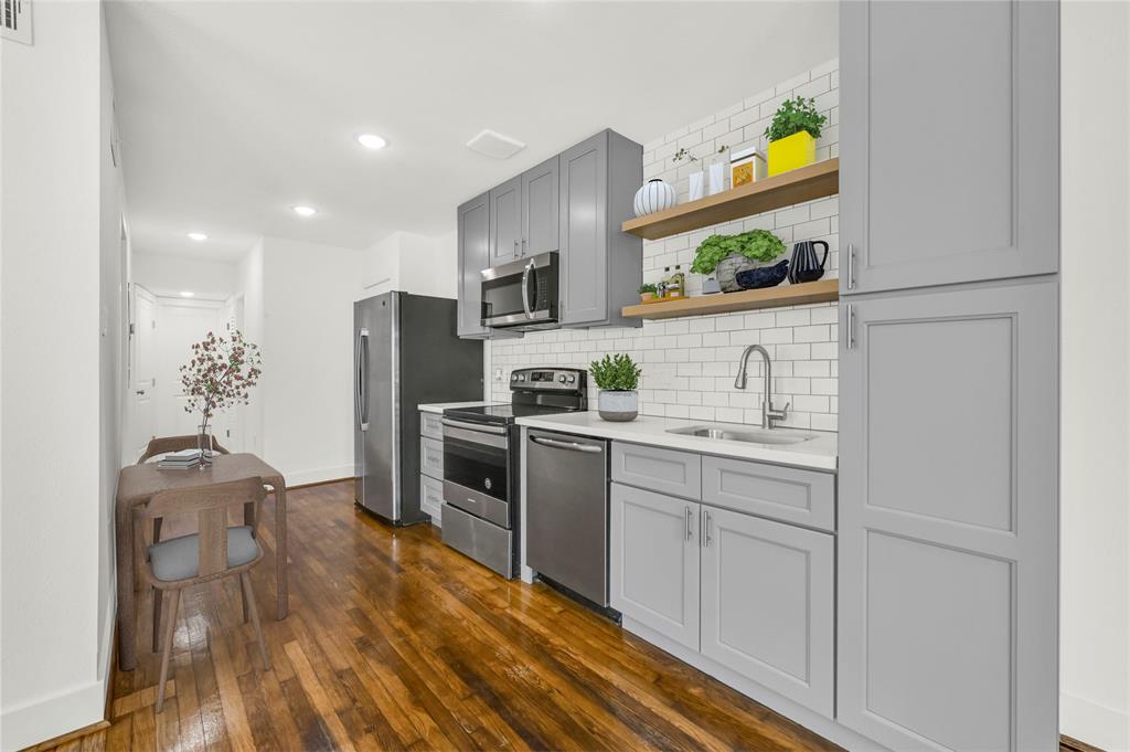 a kitchen with stainless steel appliances a stove a sink cabinets and a refrigerator