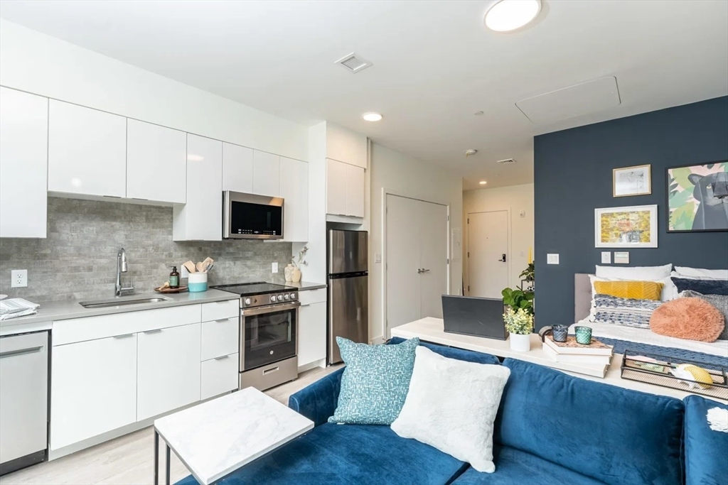 a large kitchen with cabinets wooden floor and stainless steel appliances