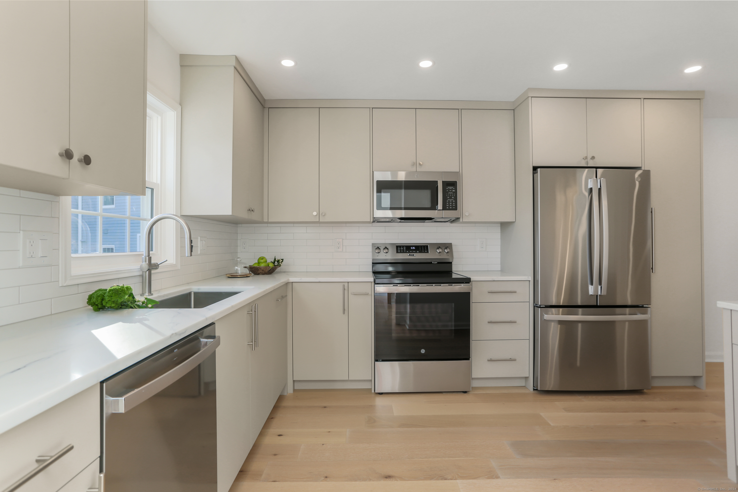 a kitchen with kitchen island granite countertop stainless steel appliances and refrigerator