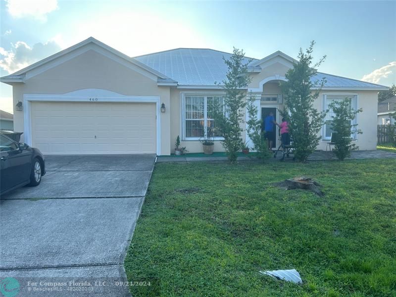 a view of a house with a yard and a garage