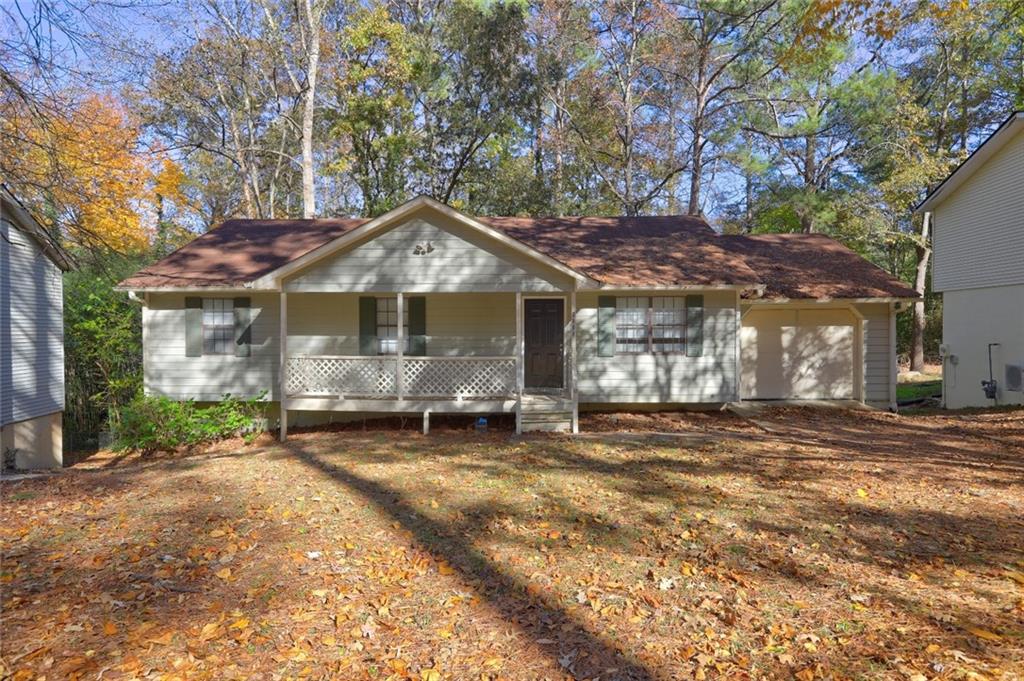 a front view of a house with a garden and trees