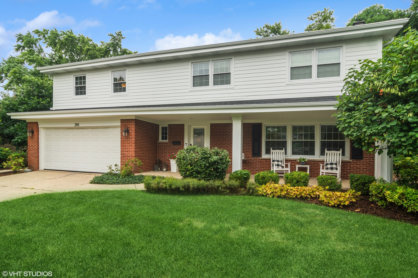 a front view of a house with a garden and yard